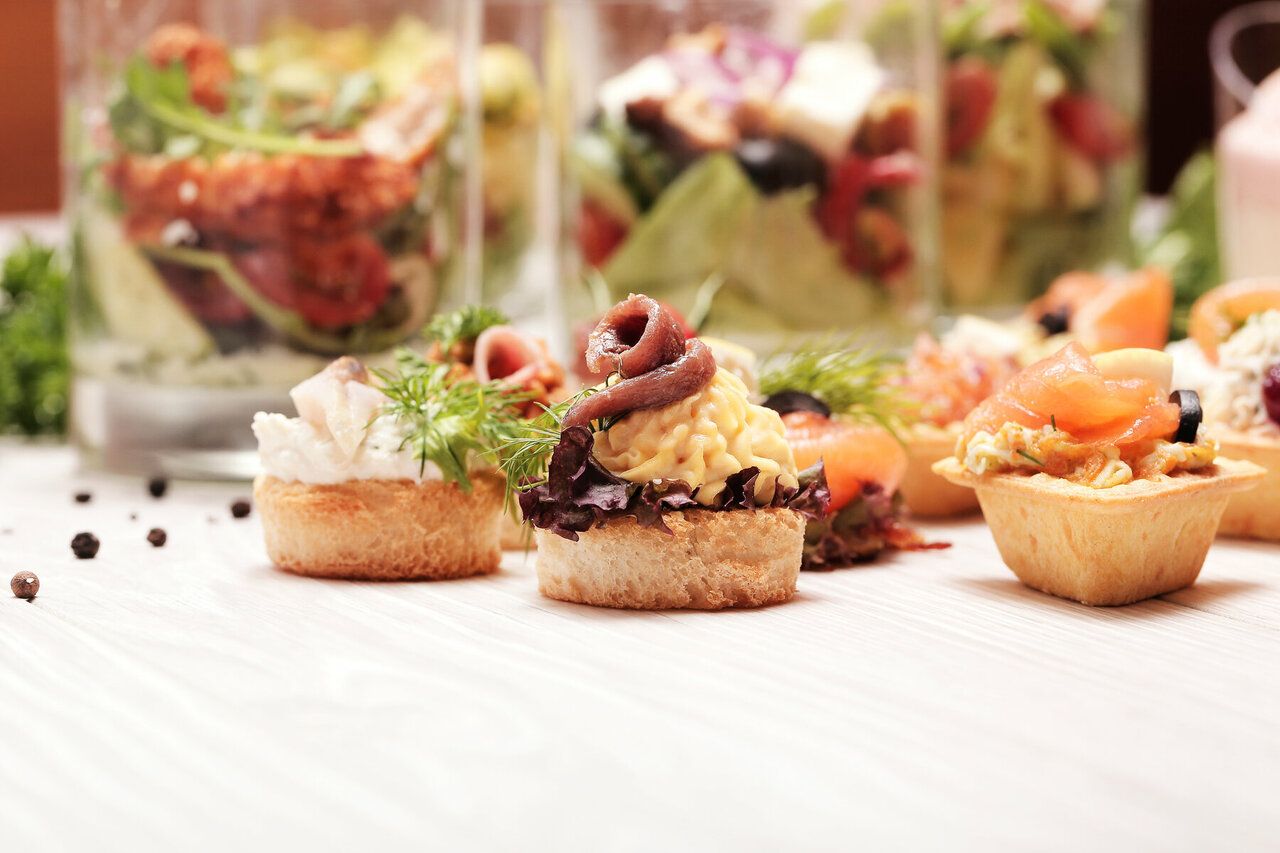 Assortiment de bouchées, tartines et verrines sur un buffet