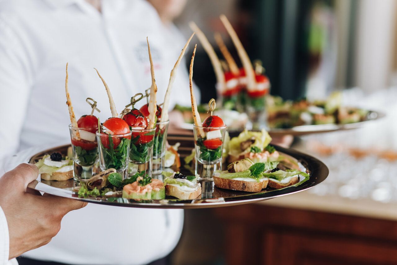 Plateau de bouchées présenté par un serveur